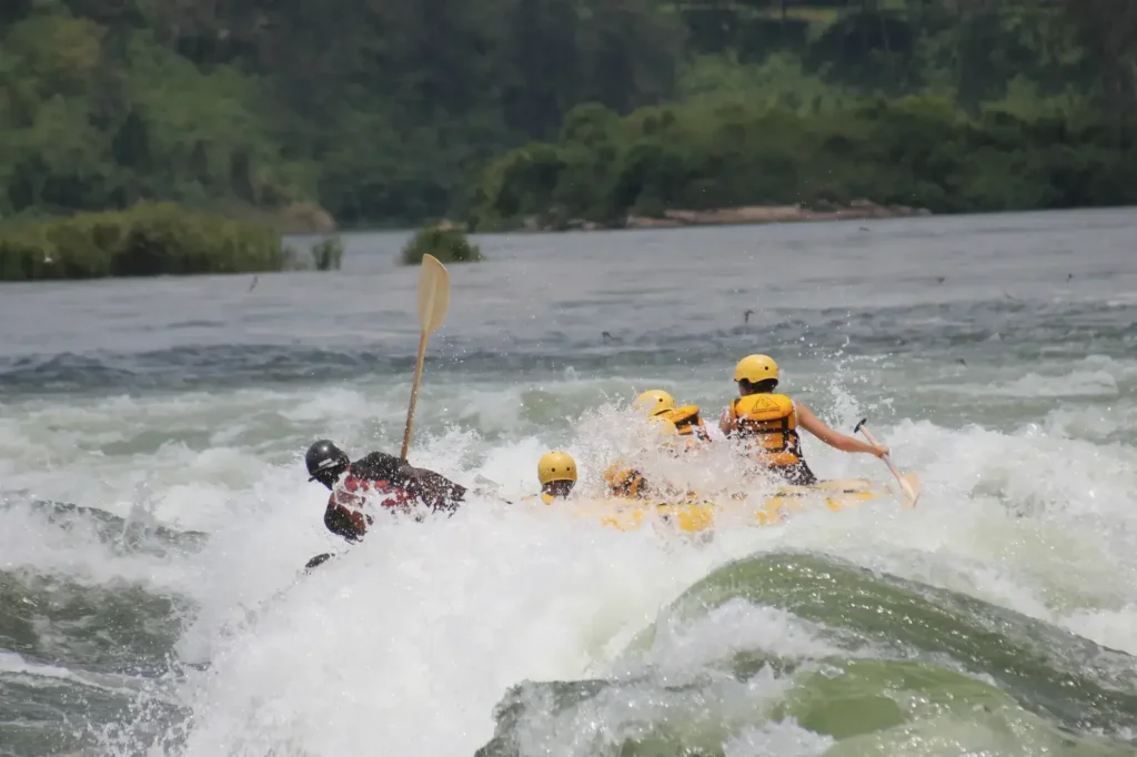 Group of MIANA tourists rafting on the Nile River in Jinja, Uganda, navigating powerful white-water rapids with professional guides.