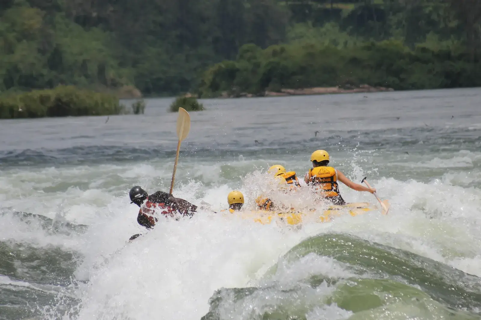 Group of MIANA tourists rafting on the Nile River in Jinja, Uganda, navigating powerful white-water rapids with professional guides.